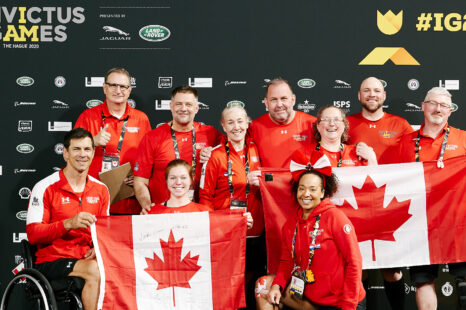 athletes and team members holding the Canadian flag